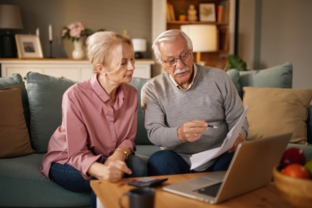 elderly couple is sitting on a blue sofa